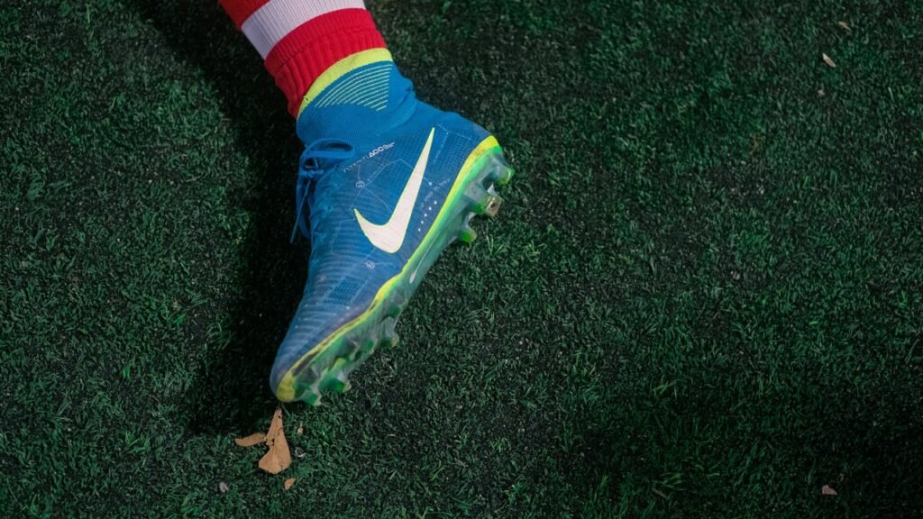 Close-up of a blue Nike soccer boot on dark grass