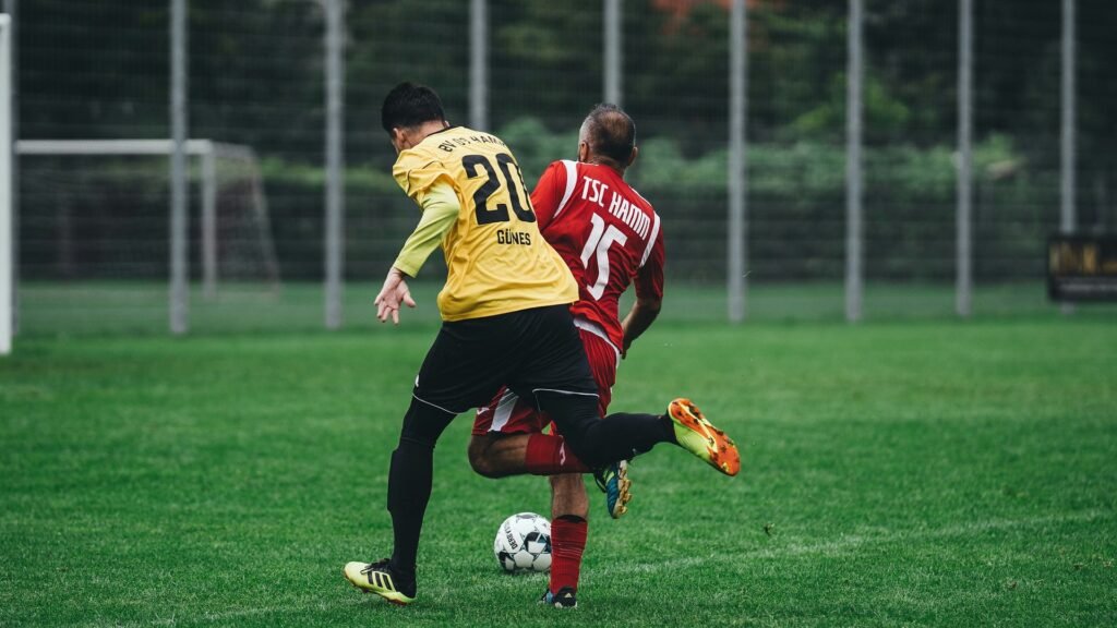 Two players competing for the ball on grass