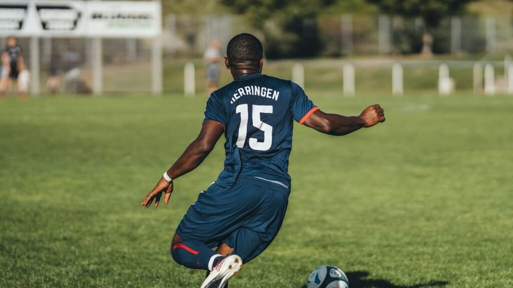 Midfielder in a navy kit dribbling forward